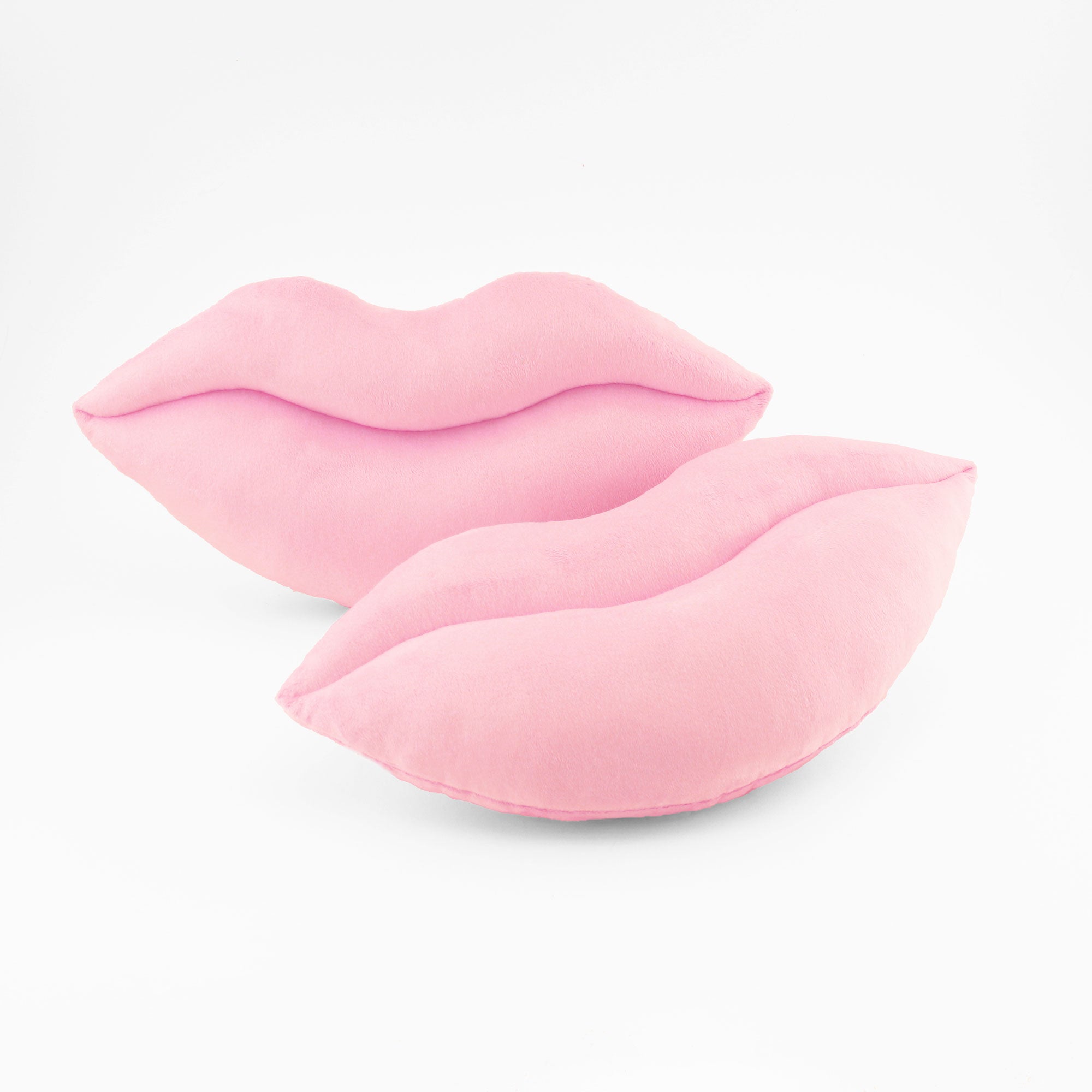 A pair of light baby pink lips shaped decorative throw pillows.