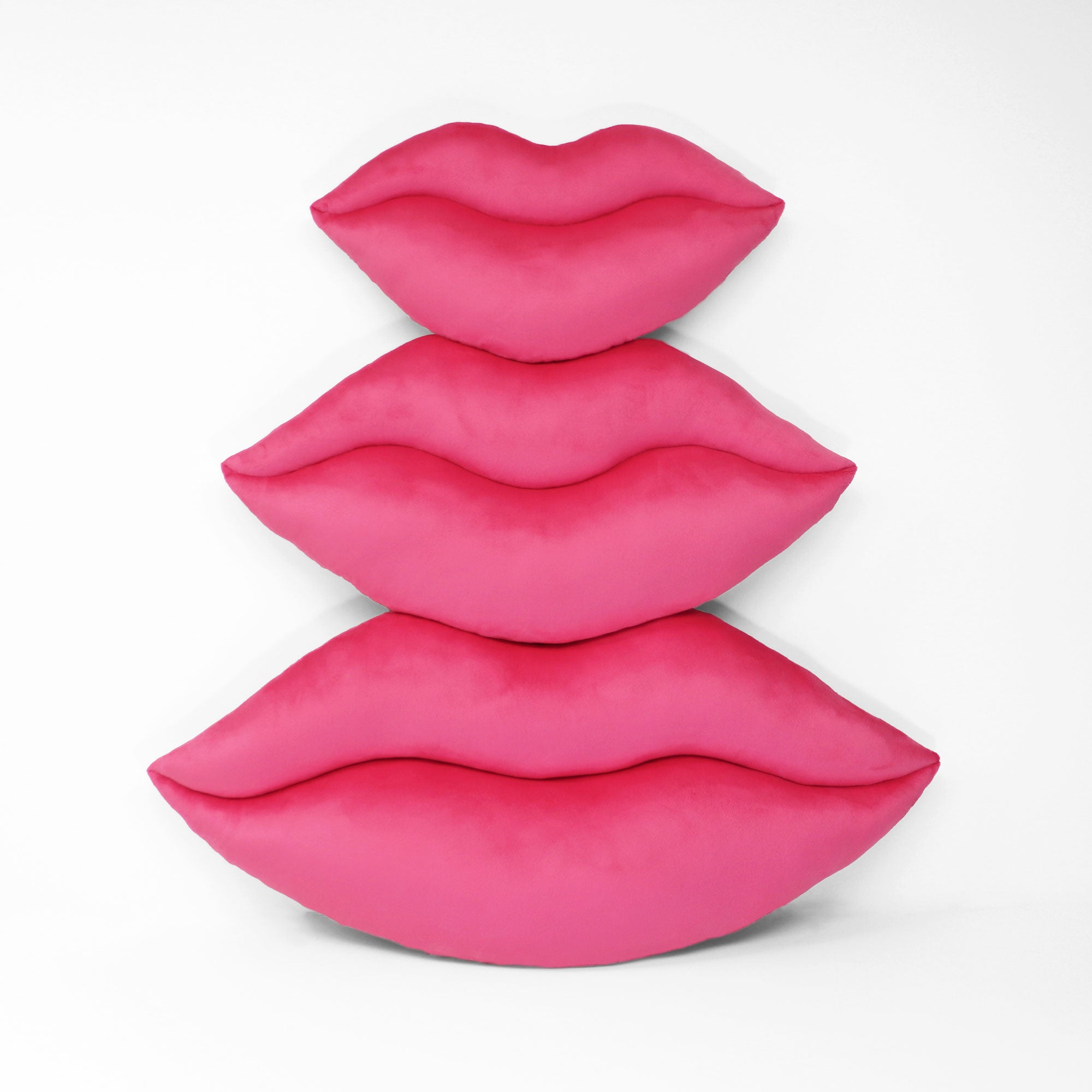 Three sizes of Hot Pink lips shaped decorative pillows.