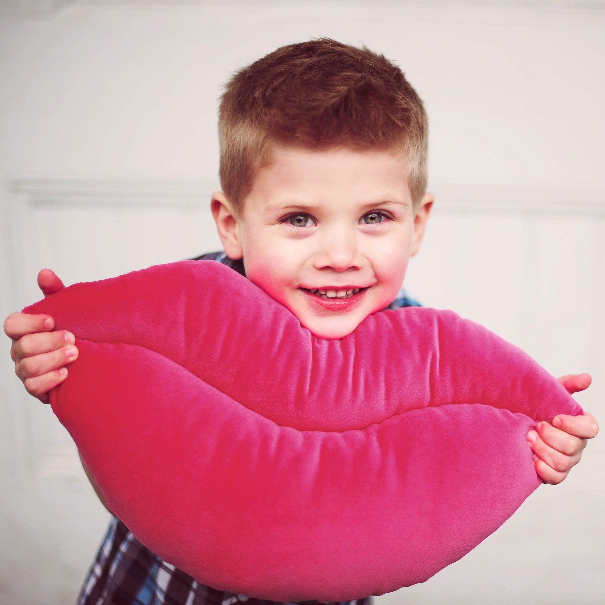 Little boy with a Hot Pink Smooch, lips shaped decorative pillow.