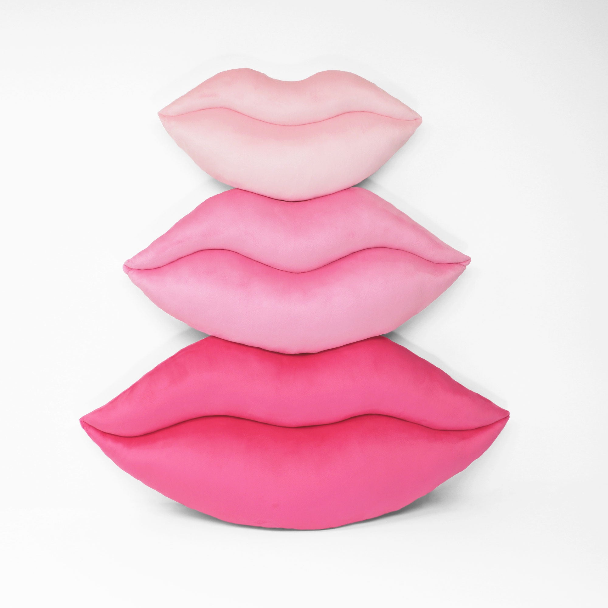 Lips shaped decorative pillows shown in three colors and three sizes.