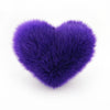 A Purple faux fur heart shaped decorative pillow.