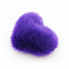 A side view of a Purple faux fur heart shaped decorative pillow.