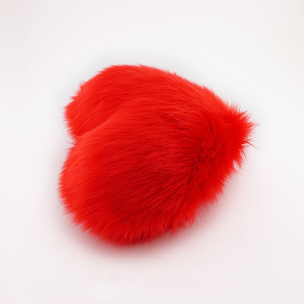 Side view of a Scarlet Red faux fur heart shaped decorative pillow.