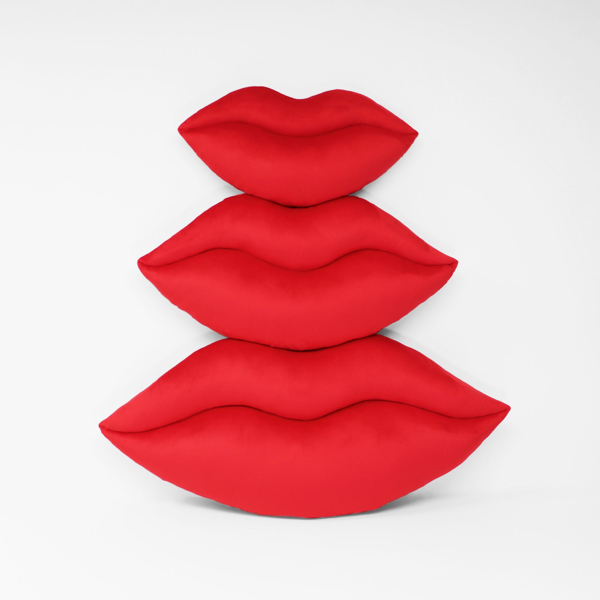 Scarlet Red lips shaped decorative pillows shown in three sizes.