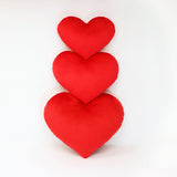 Scarlet Red heart shaped decorative throw pillows shown in three sizes.
