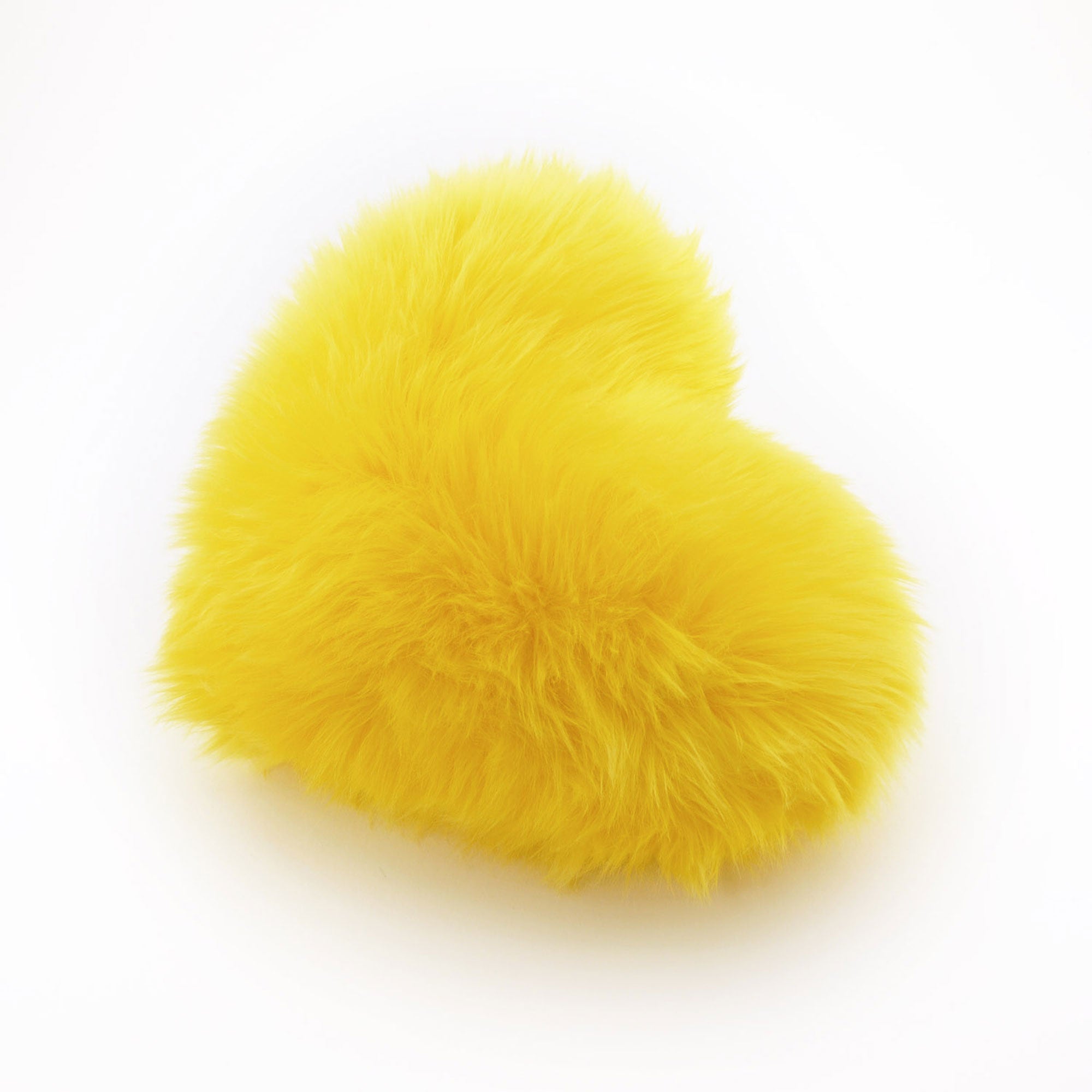 Side view of a bright Yellow faux fur heart shaped decorative pillow.